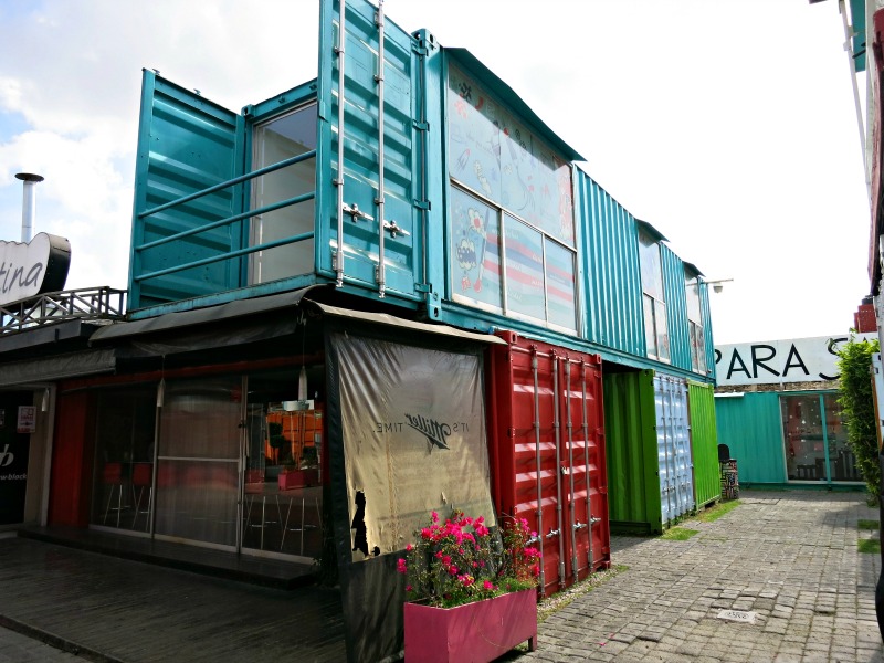 This long container straddles three containers and a corridor and still cantilevers beyond the edge of the red container below.