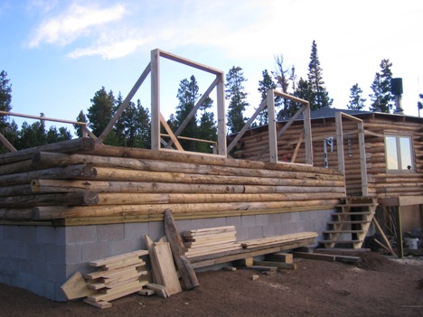 View of the log home with the walls just started