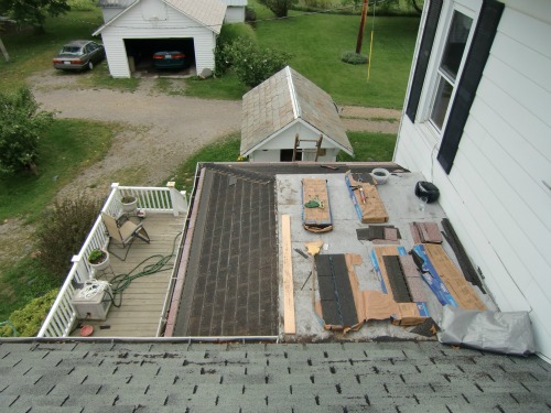 Roof Repair - Here the tabs have been cut off the small roof skirting the flat roof.