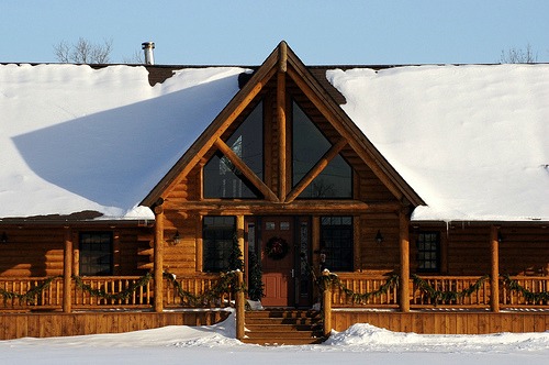 Log home plans range from rustic to modern.  This one blends contemporary windows with a traditional layout.