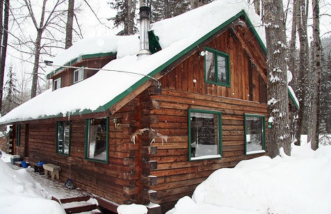 log home with green border under snow - courtesy of Iwona Kellie at Flickr