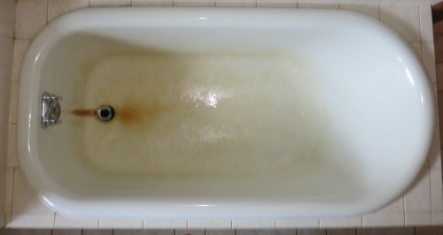 How can I remove old caulk from a bathtub that has been refinished?