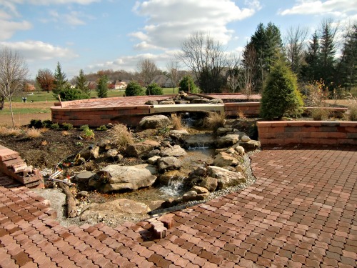 The unfinished garden with a waterfall fed by the rainwater collection system