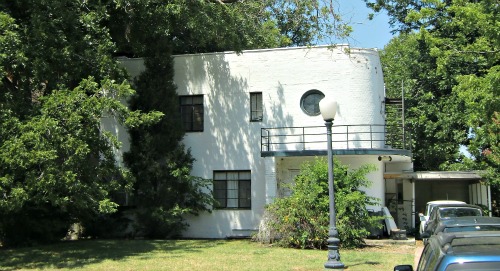 This 1933 Art Deco home has no exterior ornamentation.  The bricks are painted white to produce a stark, flat look.  Balconies were a common feature of Art  Deco homes, often lacking any protective roof over the porch.  The whole look was called "Streamline Ship", drawing inspiration from ocean liners.