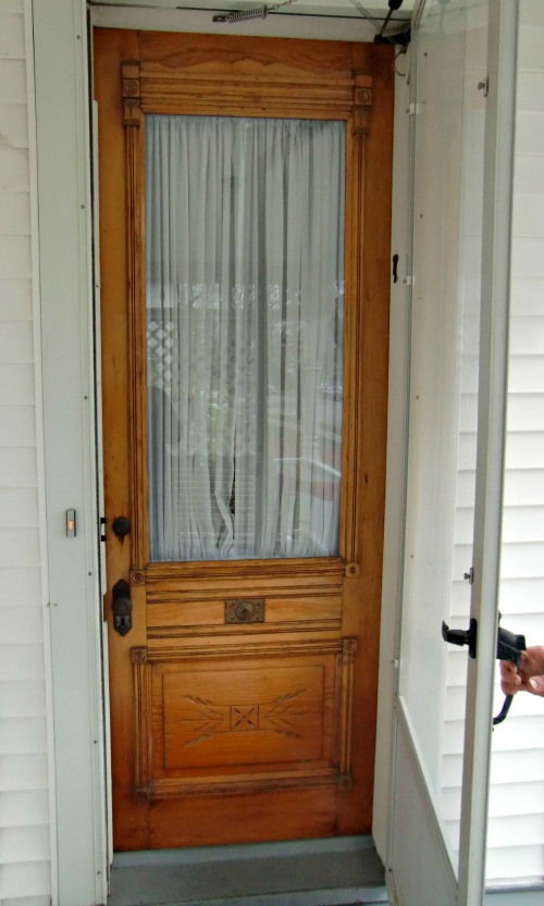 This is a beautiful wood door that is partially obscured by storm door.  A full glass storm door would be an improvement, although no storm door would look best.