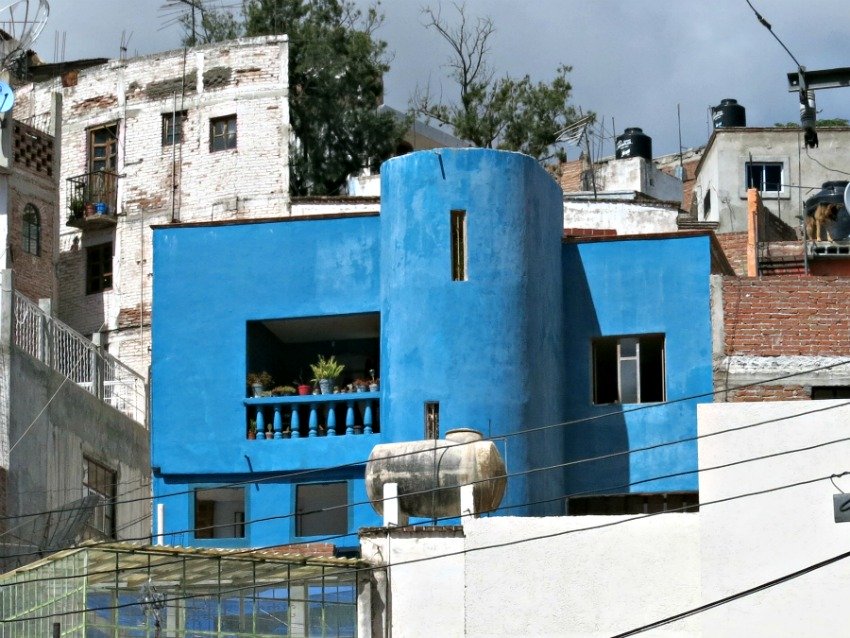 A colorful house placed on a steep slope stands out for miles. Many Mexican houses are a vibrant blue.