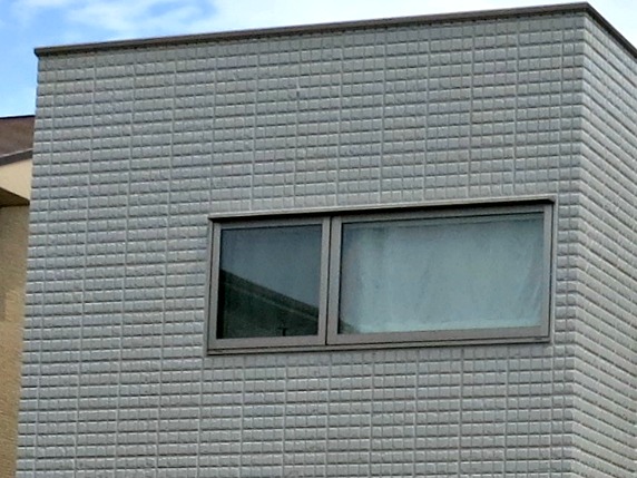 A grid of bricks without any overlapping gives this away as panels of faux brick siding. Real brickwork in Japan still exists but is increasingly rare.