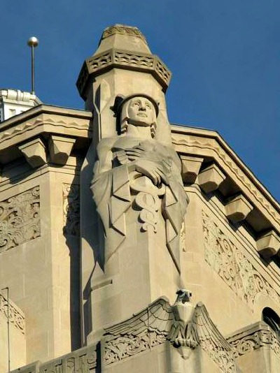 Art Deco skyscraper the Times Atlas building has some sentries on duty at at the top of the tower.  