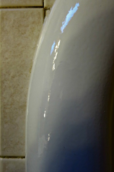 This photo has been darkened to show the orange peel better. Most bathtub refinishing jobs have this slightly irregular surface texture.
