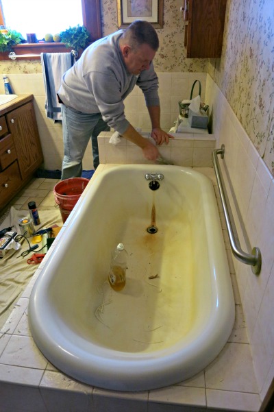 A good refinishing requires a good prep.  Here Dave Crissman takes off the calk that sealed the gap between the tub and the tile.